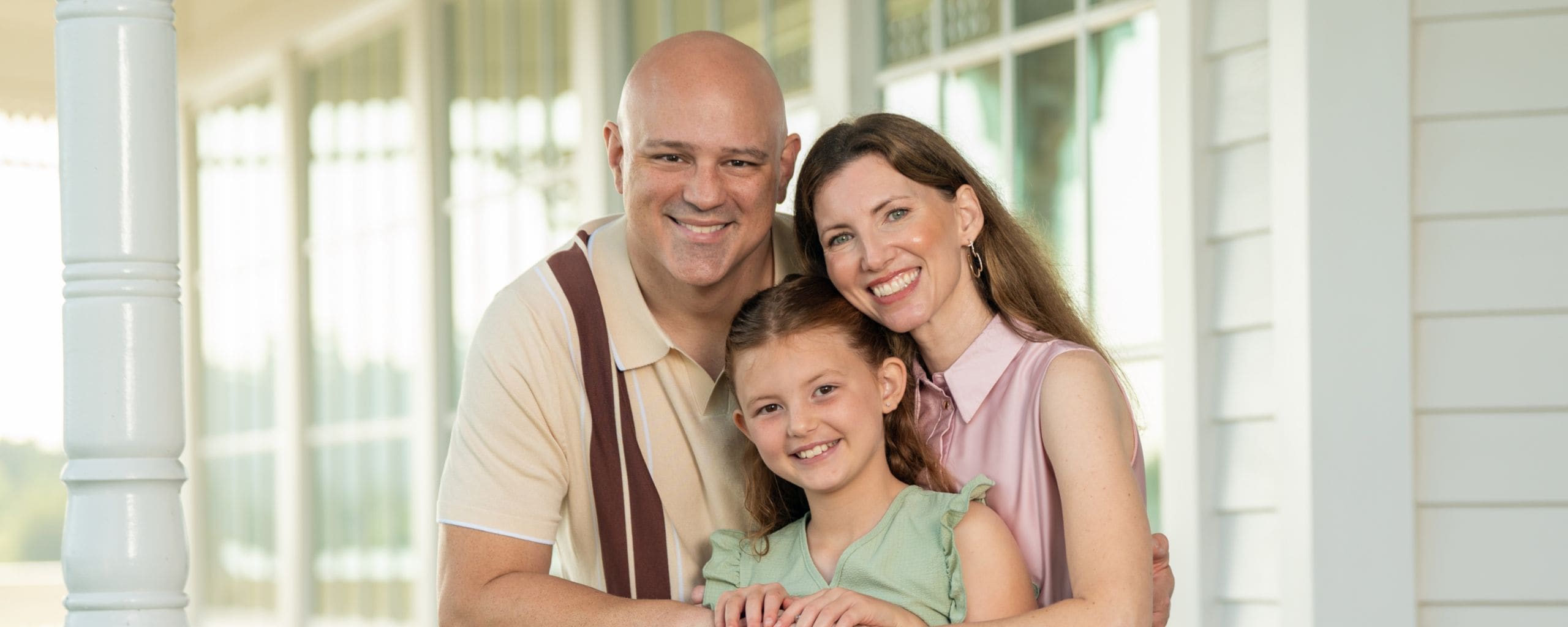 A family of 3 posing for a photo during a portrait session at Walt Disney World Resort